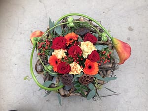 Bloemen in houten takkenkrans rood allerheiligen