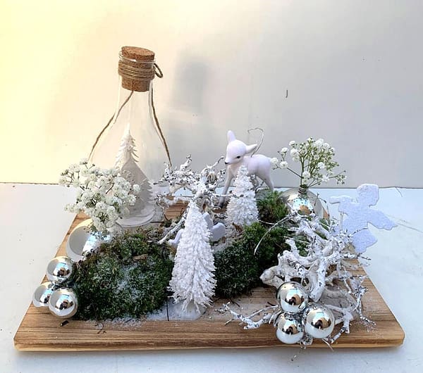 Kerst-tafereel met glazen fles, boompjes en bloemetjes